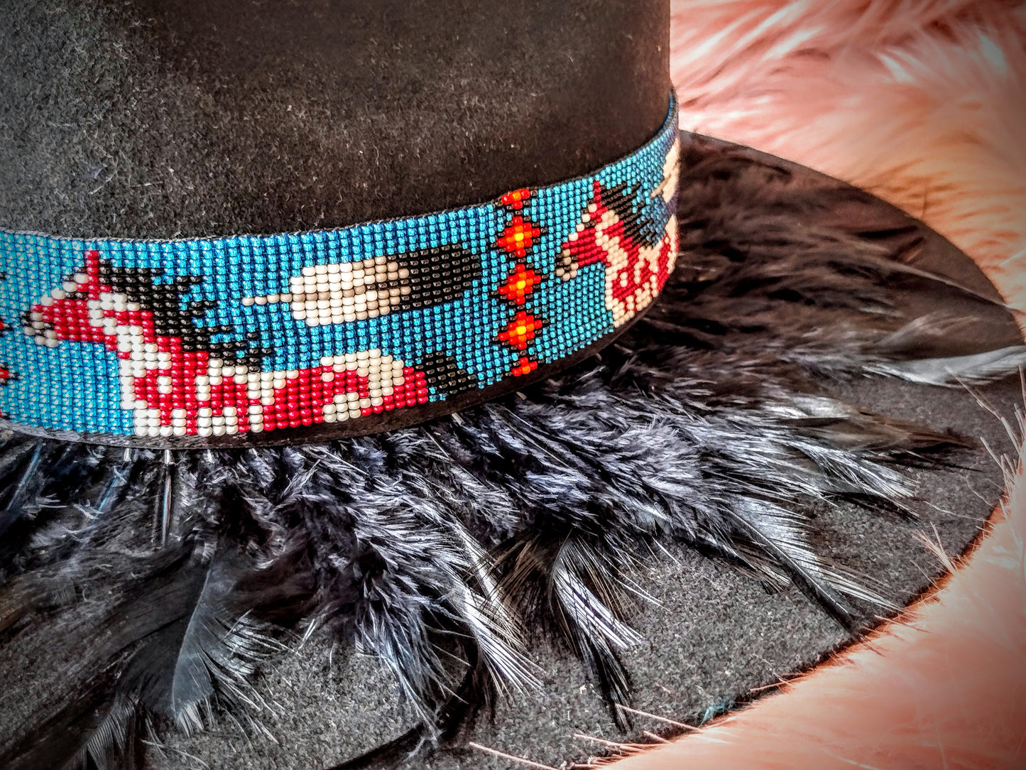 Hat embellished with feather art and beaded work.