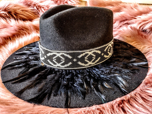 Hat embellished with feather art and beaded work.