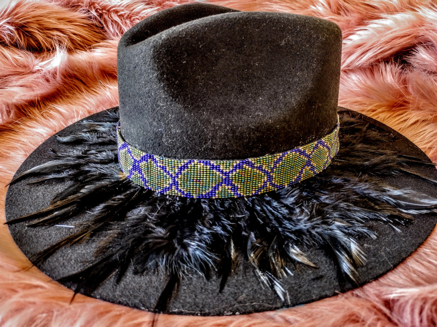 Hat embellished with feather art and beaded work.