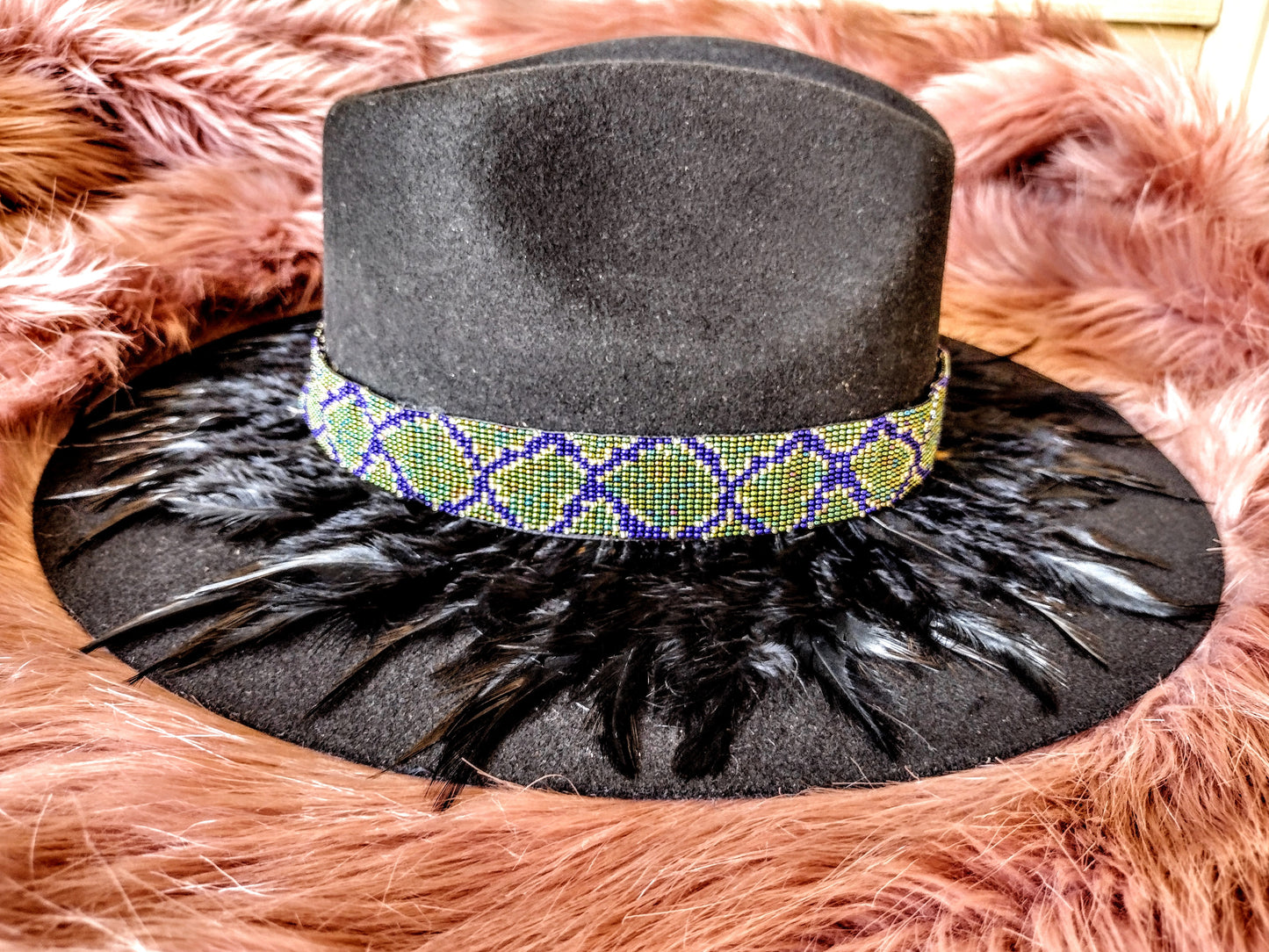 Hat embellished with feather art and beaded work.