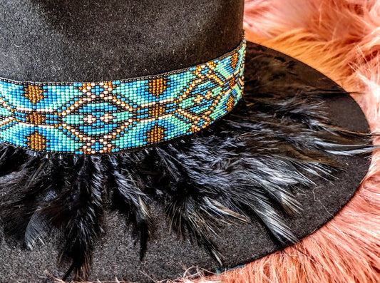 Hat embellished with feather art and beaded work.