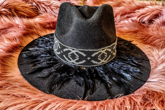 Hat embellished with feather art and beaded work.