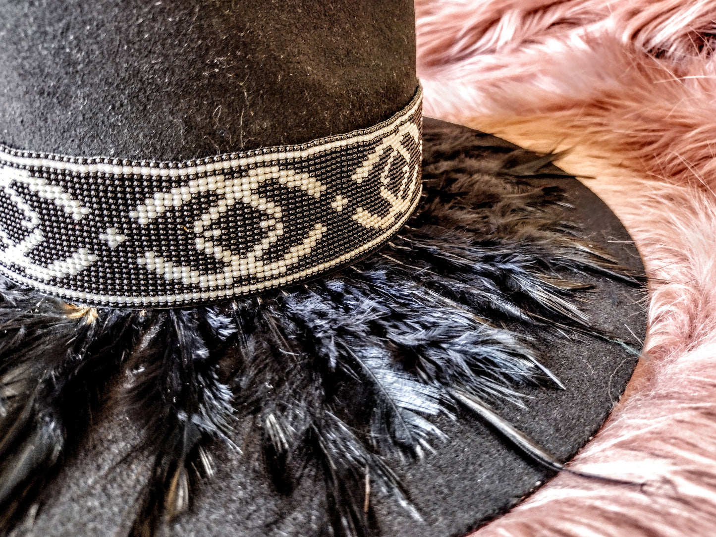 Hat embellished with feather art and beaded work.