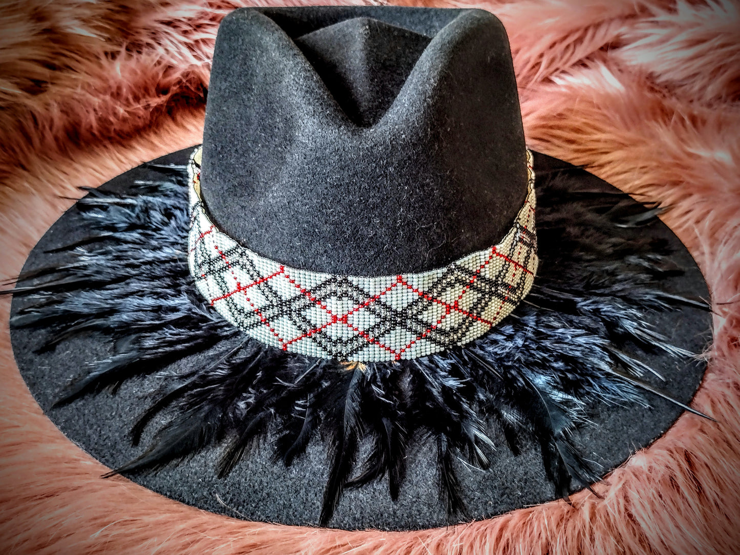 Hat embellished with feather art and beaded work.