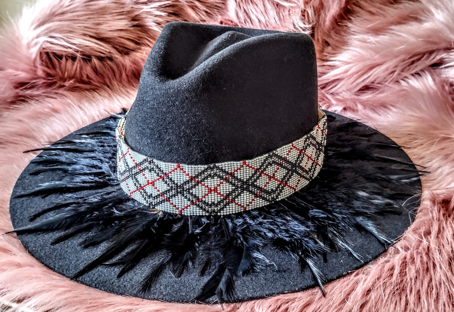 Hat embellished with feather art and beaded work.