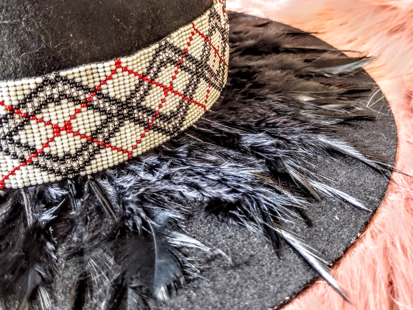 Hat embellished with feather art and beaded work.