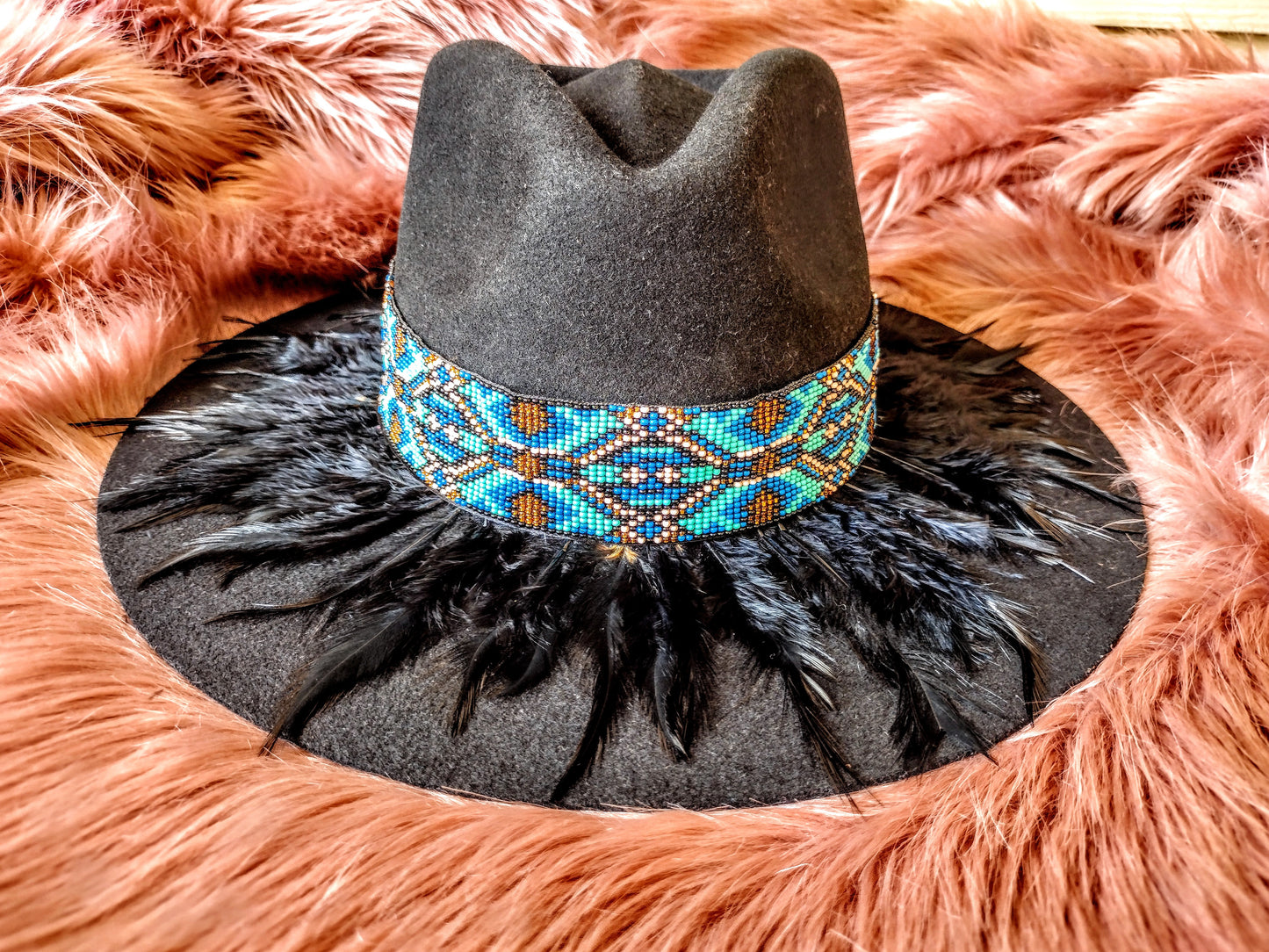 Hat embellished with feather art and beaded work.