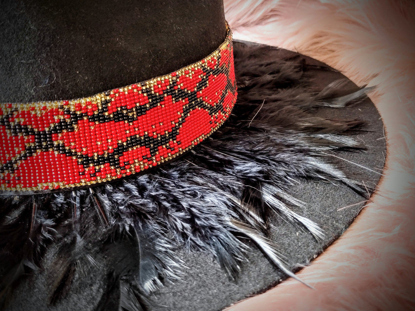 Hat embellished with feather art and beaded work.