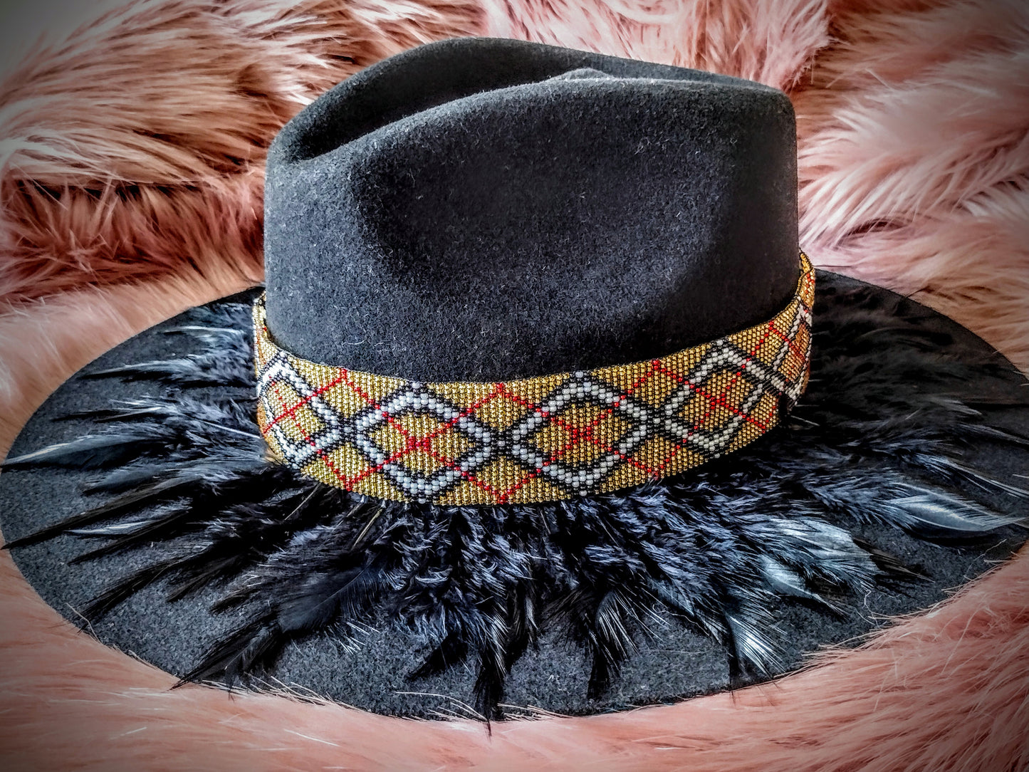 Hat embellished with feather art and beaded work.