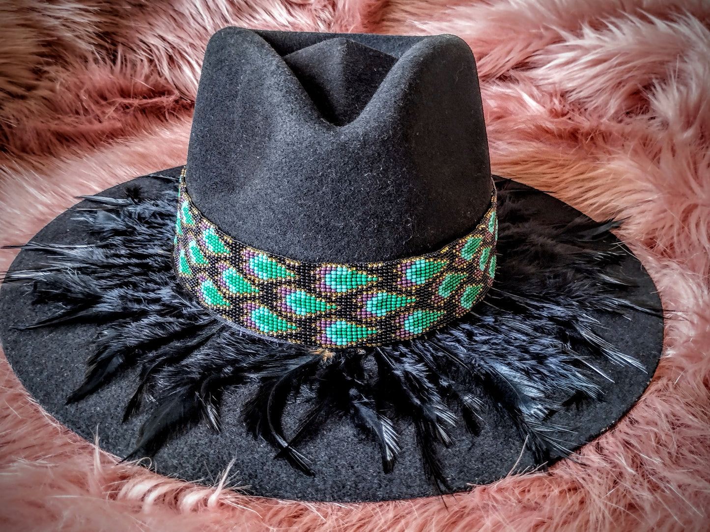 Hat embellished with feather art and beaded work.