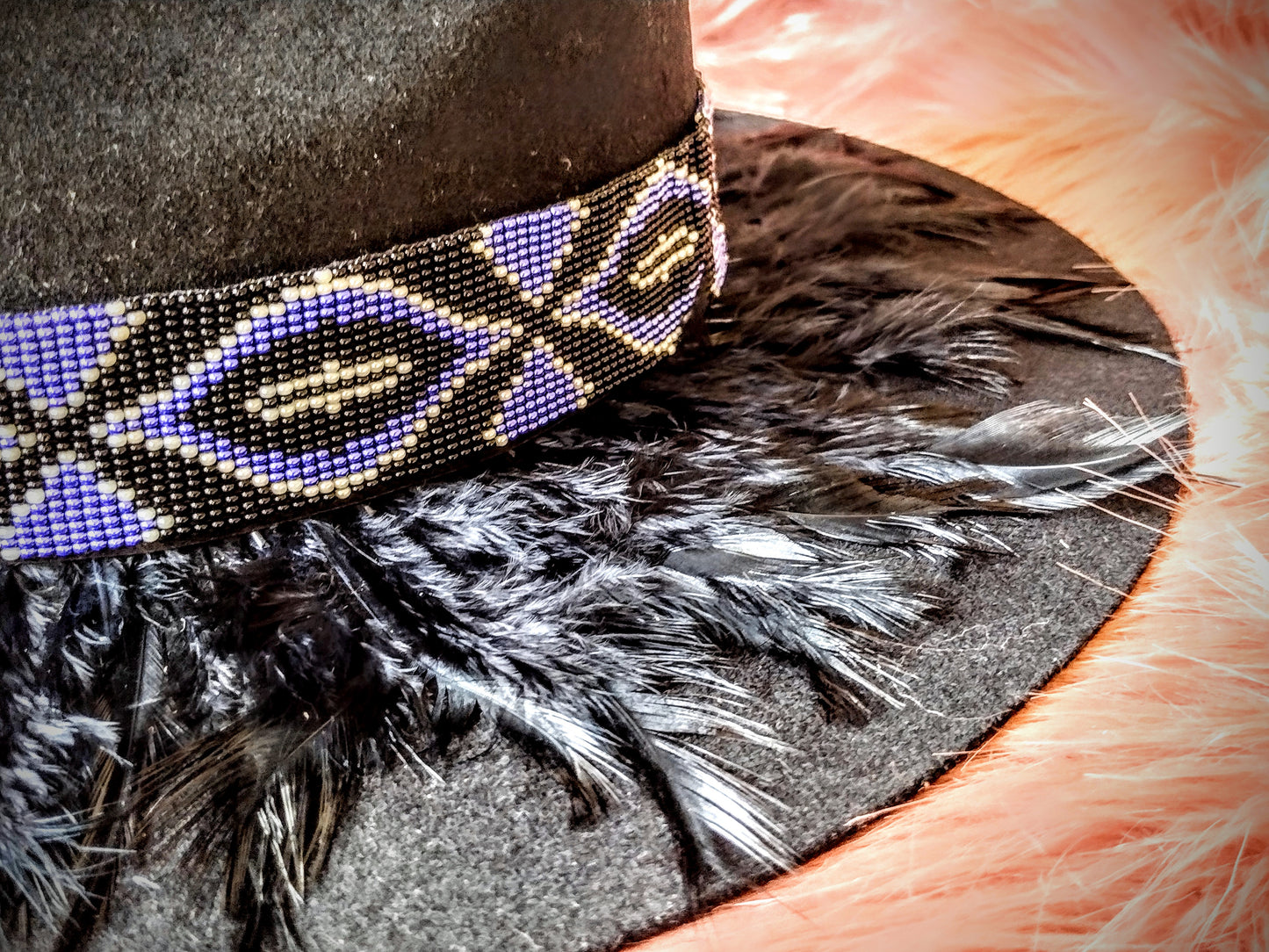 Hat embellished with feather art and beaded work.