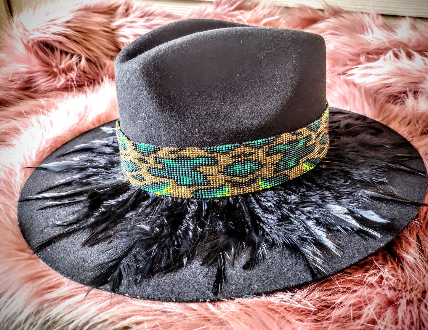 Hat embellished with feather art and beaded work.