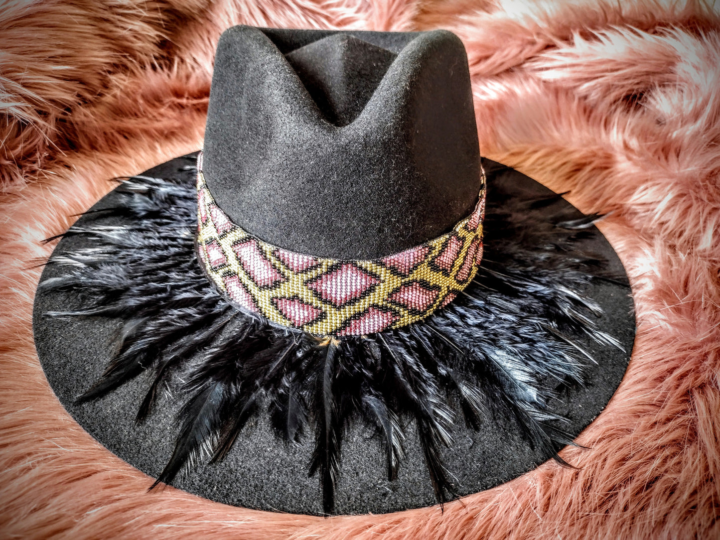 Hat embellished with feather art and beaded work.