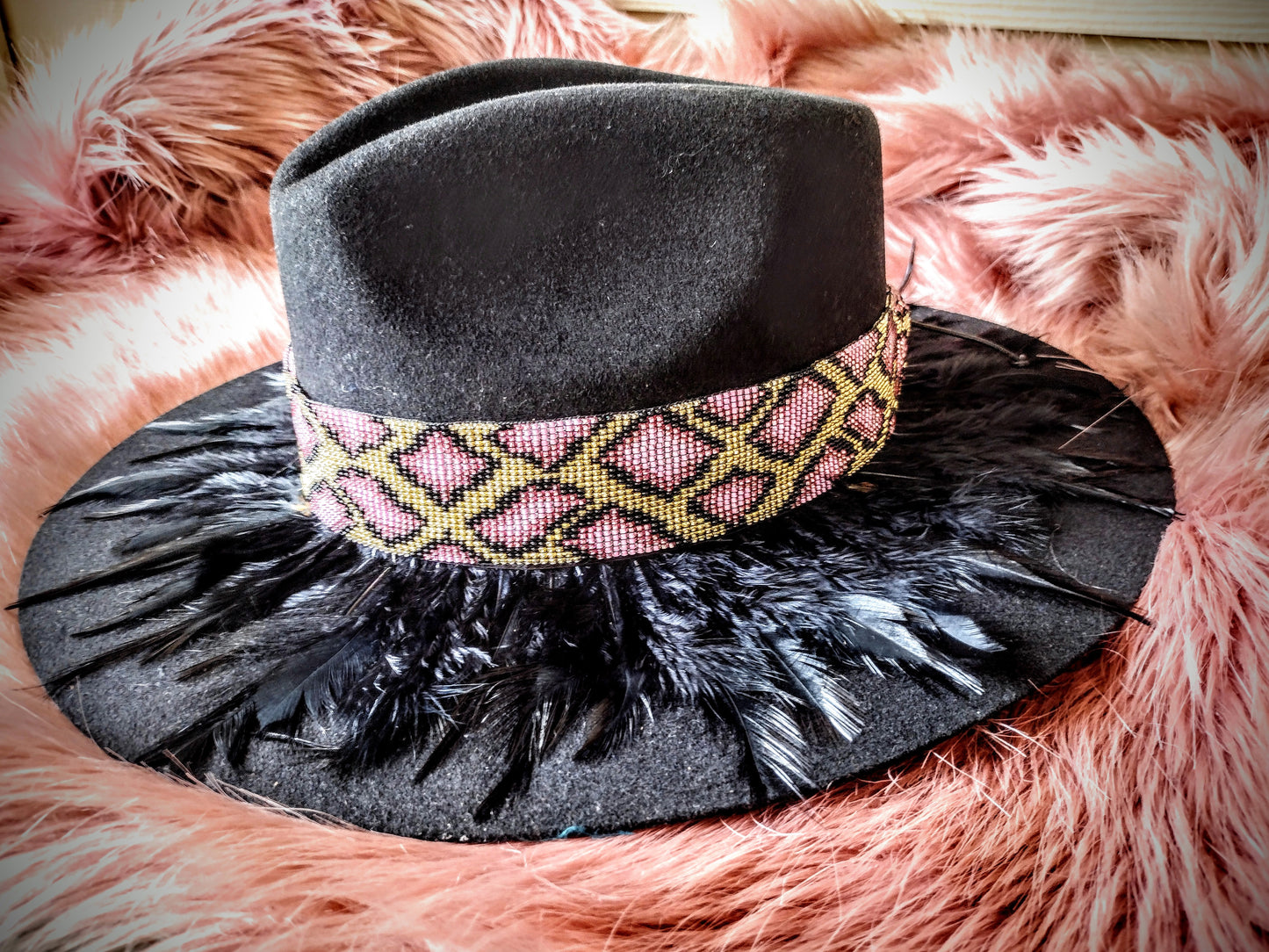 Hat embellished with feather art and beaded work.