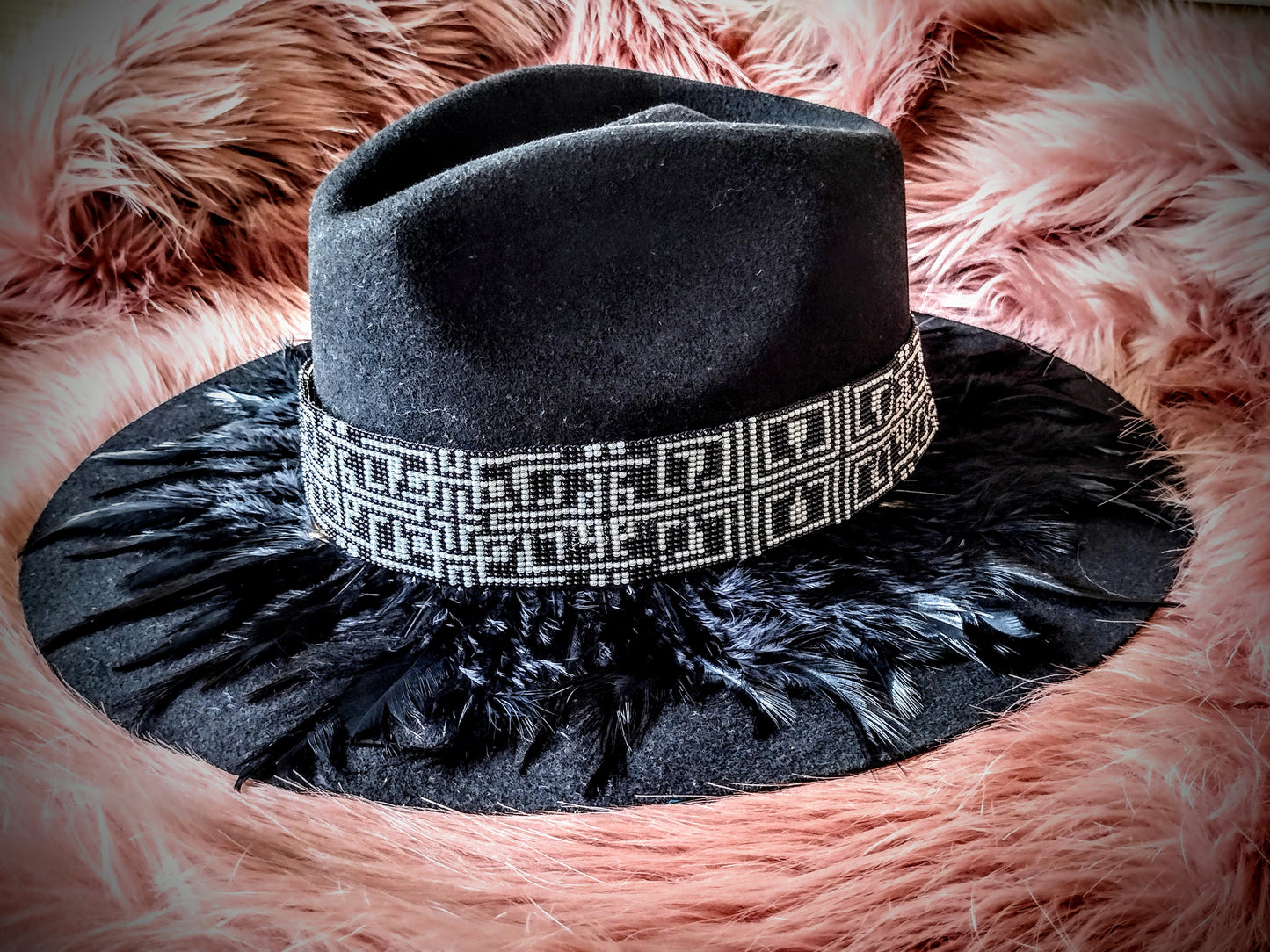 Hat embellished with feather art and beaded work.